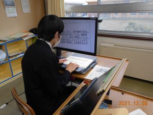 拡大読書器を用いて本紹介の原稿を読む生徒