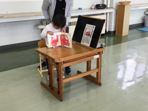 しかけ絵本を操作しながら説明する幼児