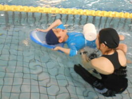 浮き具を使い、仰向けの状態で浮く感覚を楽しむ児童