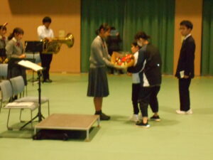 富山第一高等学校吹奏楽部の皆さんに花束を贈る児童