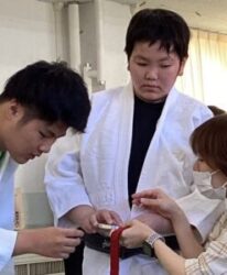 実物の銀メダルに触れて形や点字を確かめる児童