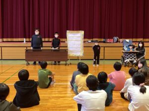藤ノ木小学校の児童の前で挨拶や司会進行をする様子